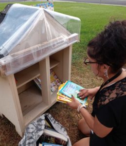 Flor Puts books into Little Library