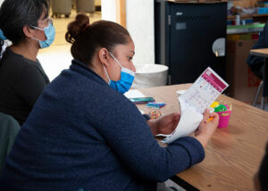 Parent reads printed material at Cafe con Flor