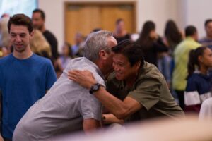 Two men hugging at a community event